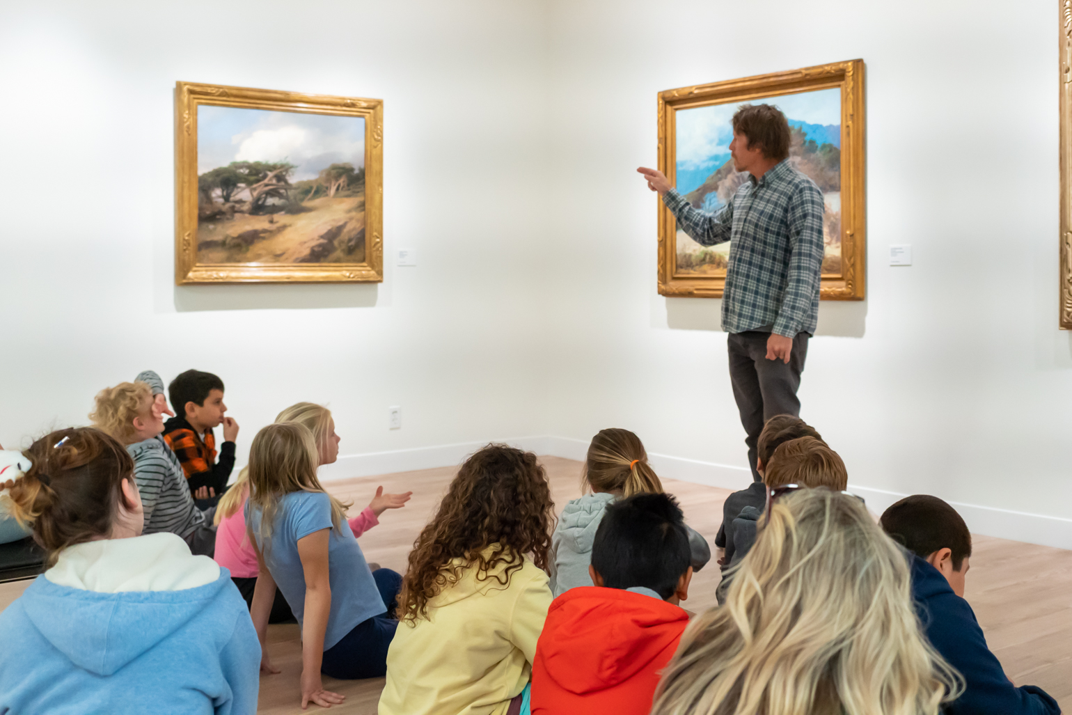 School visit with children seated in the gallery viewing artwork