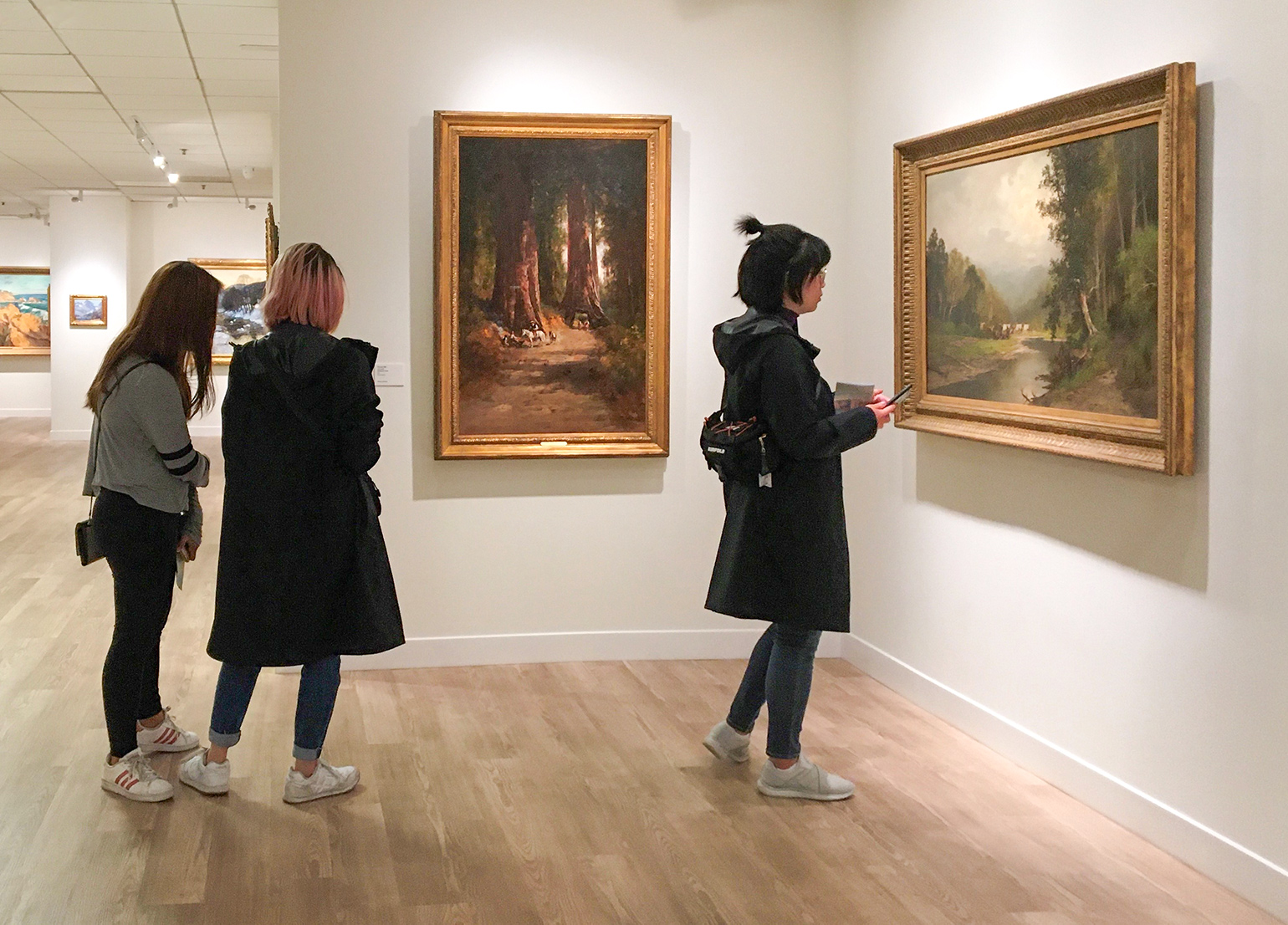 visit1 Installation view of Sublime Wonderlands exhibition with visitors looking at paintings