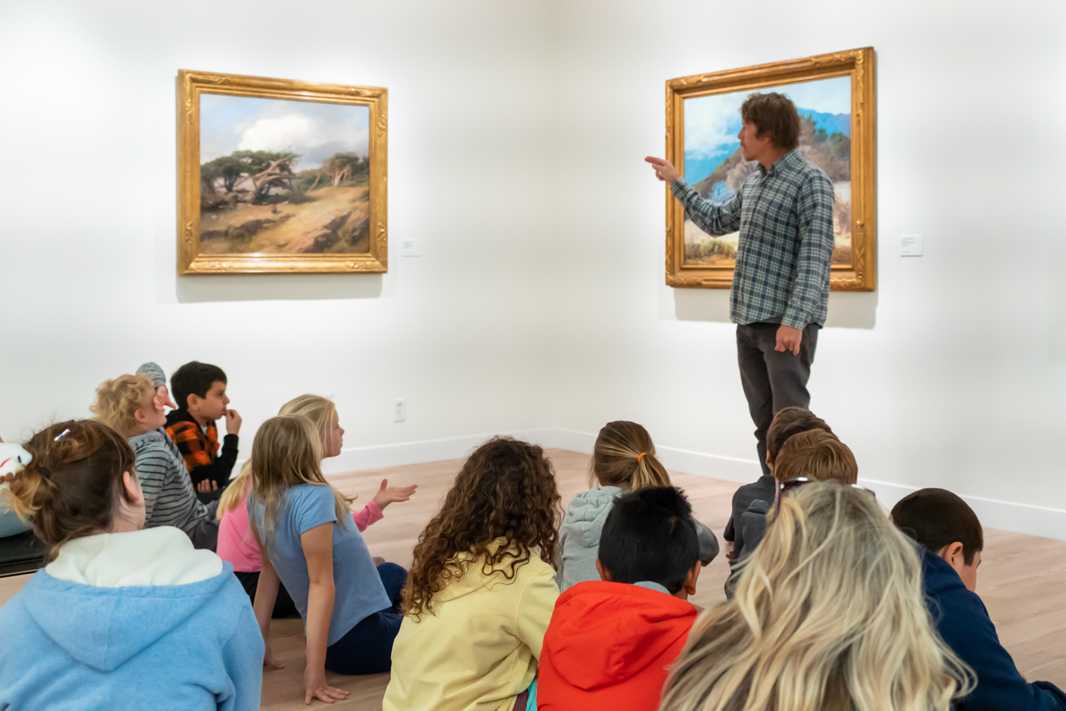 School visit with children seated in the gallery viewing artwork