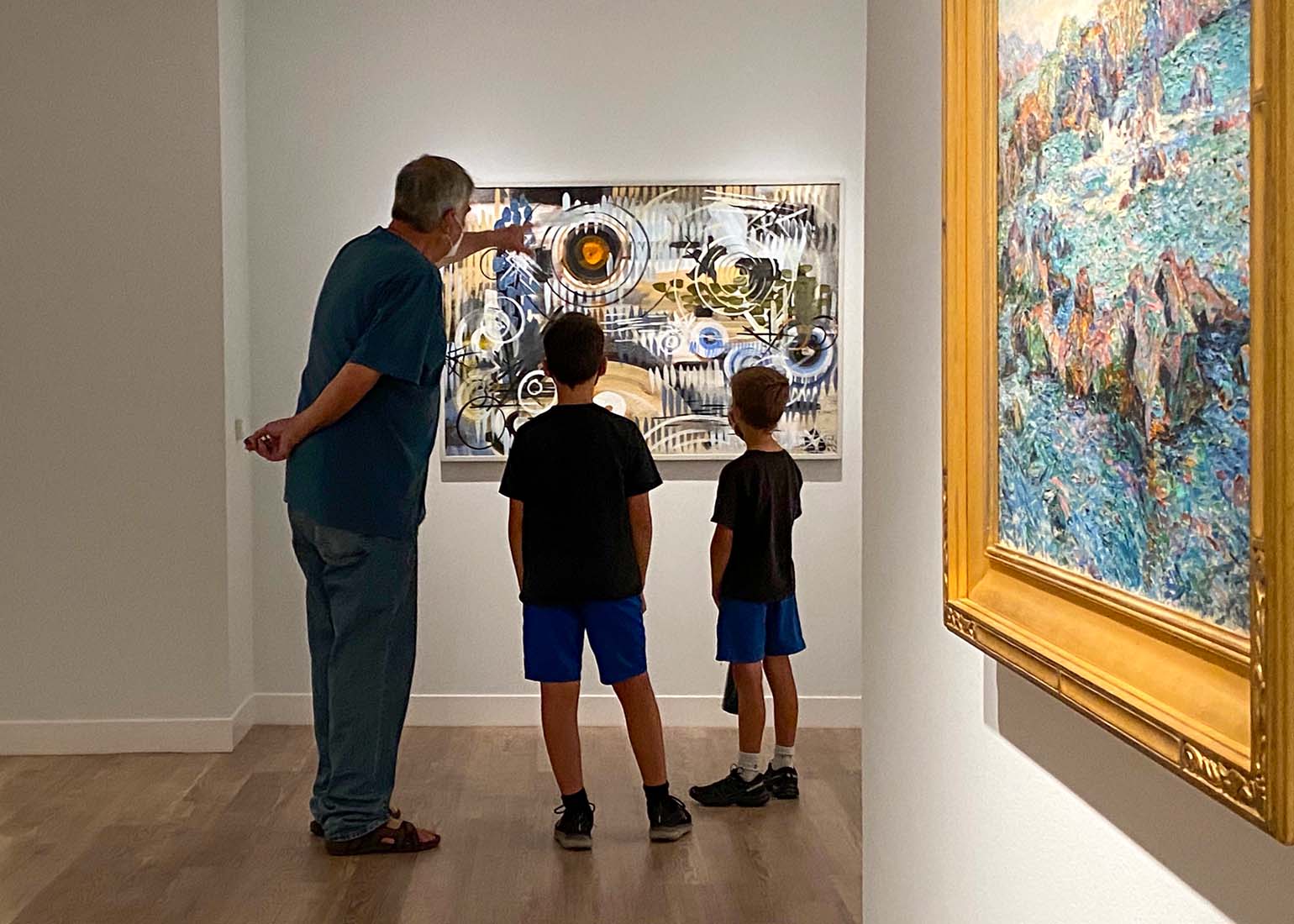 7485 An adult and two children looking at a painting in the museum