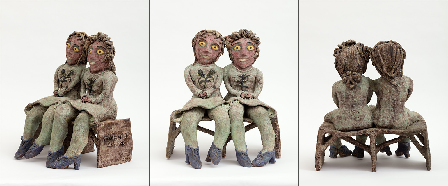 A ceramic sculpture of two people on a bench