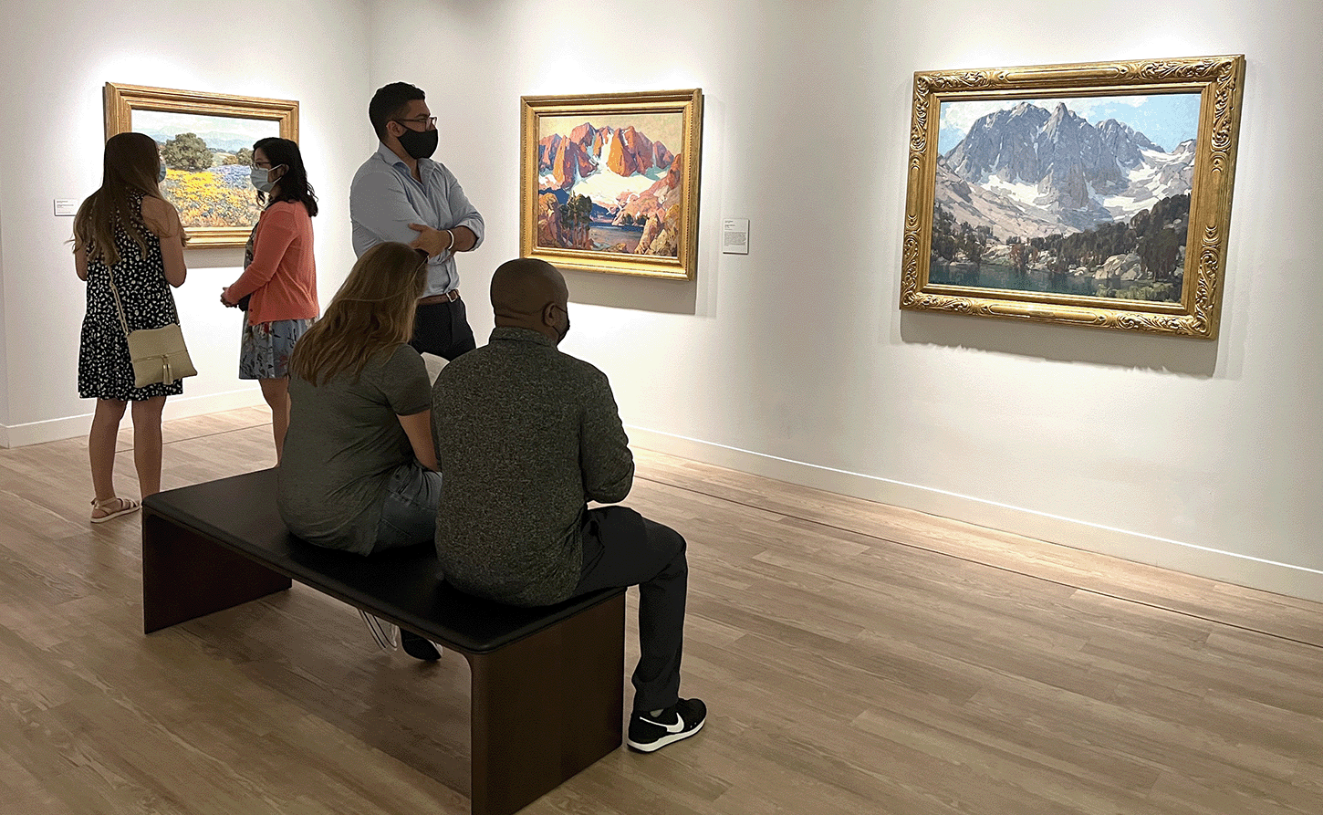Installation view with visitors, <em>Variations of Place: Southern California Impressionism in the Early 20th Century</em>, 2022, Photo by Julie Delliquanti © The Regents of the University of California