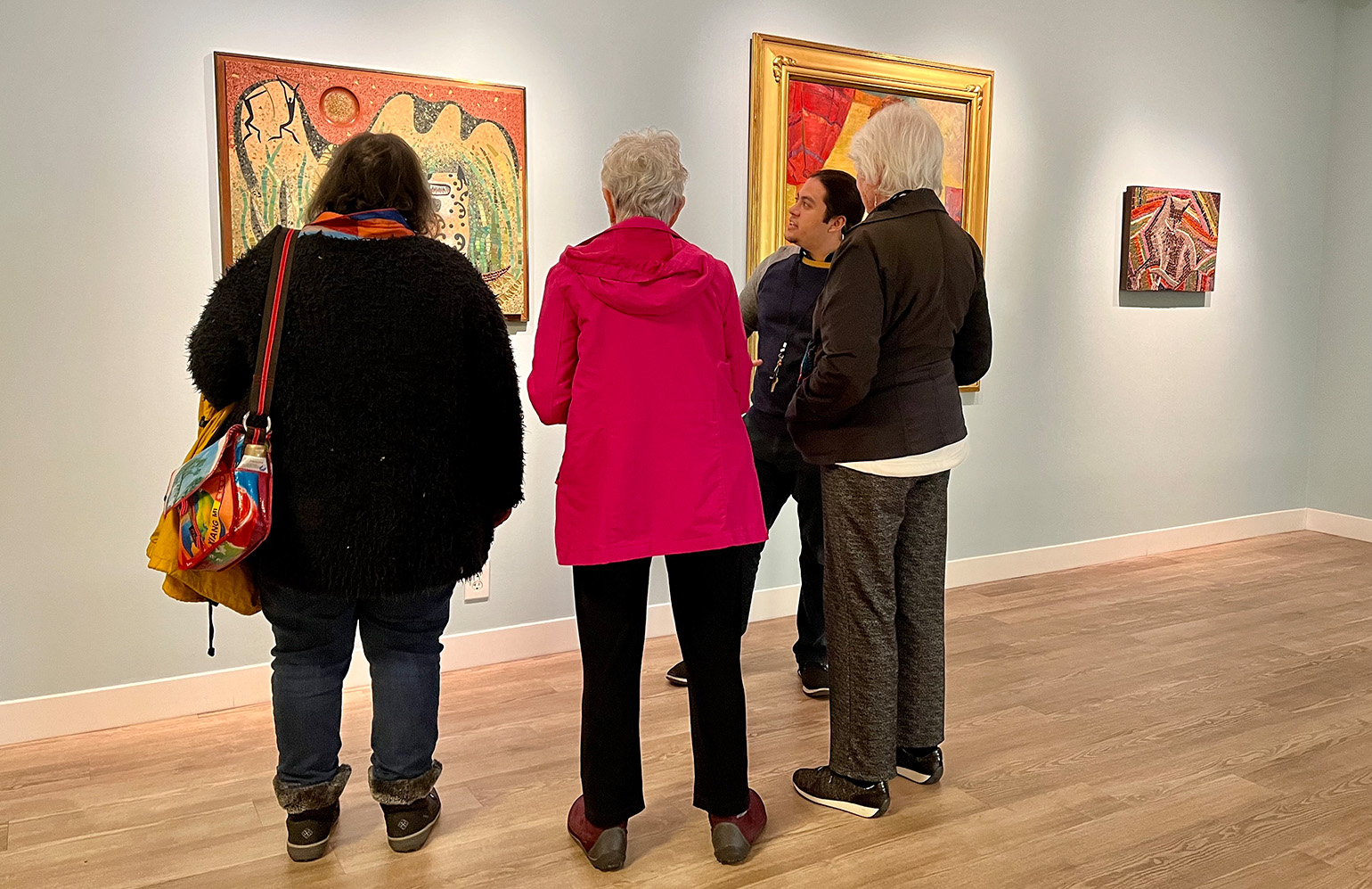 Sebastián Vizcaíno Cortés, Visitor Experience Coordinator, with visitors in <em>The Bruton Sisters: Modernism in the Making</em>, 2023. Photo by Julie Delliquanti © The Regents of the University of California