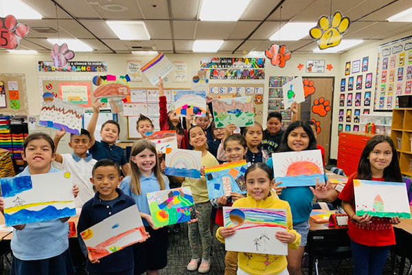 Elementary school students showing the art they created.